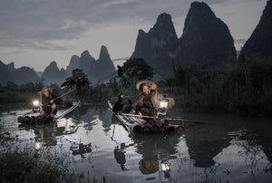 fishermen float bamboo rafts along the river using long wooden paddles