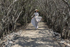 The traditional Ao Dai dress flaunting along the tree lined pass