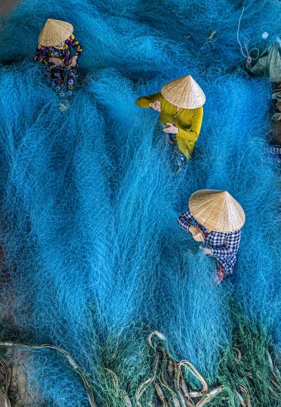 Women  engaging in weaving and repairing fishing nets